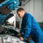 Mechanic makes visual inspection of the car engine